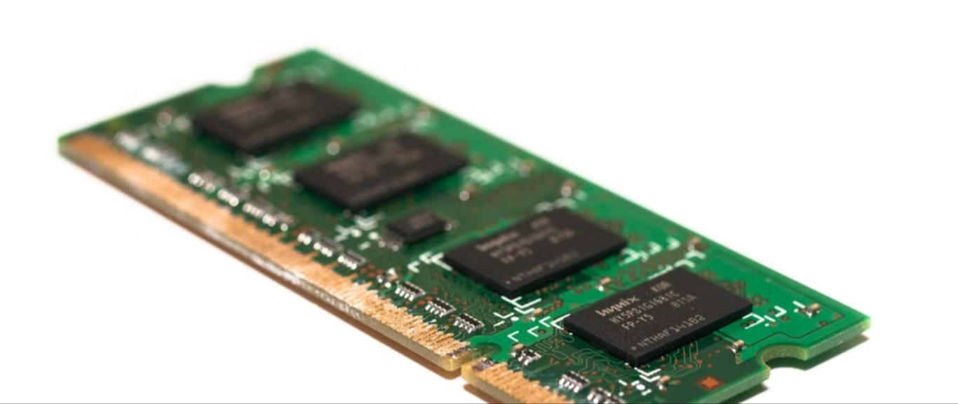 Technician installing RAM memory module upgrade in a laptop